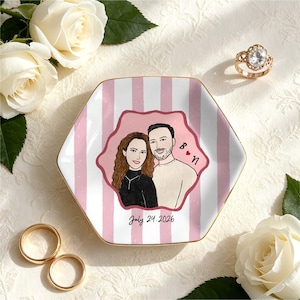 Pu&ograve; includere: Un piattino esagonale in ceramica con un motivo a righe verticali rosa e bianche. Al centro &egrave; presente un'illustrazione personalizzata di una coppia, le iniziali B e N con un cuore rosso e la data stampata July 24, 2026, in corsivo nero.