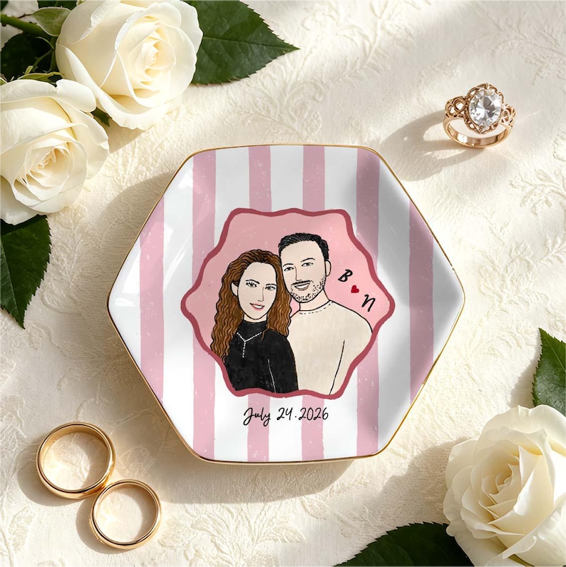 Pu&ograve; includere: Un piattino esagonale in ceramica con un motivo a righe verticali rosa e bianche. Al centro &egrave; presente un'illustrazione personalizzata di una coppia, le iniziali B e N con un cuore rosso e la data stampata July 24, 2026, in corsivo nero.