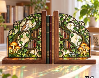 May include: A pair of wooden bookends featuring stained glass panels with an intricate forest scene. The design includes a barn owl, glowing mushrooms, ivy vines, and miniature bookshelves. The name "Oliva" is printed on the right panel.