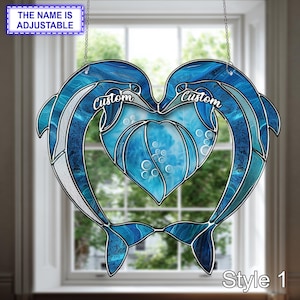 May include: A stained glass window hanging featuring two blue dolphins forming a heart shape. The design includes the text "Custom" and "Style 1". The text "The Name Is Adjustable" is also visible.