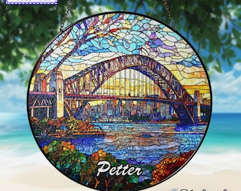 May include: A circular stained glass suncatcher featuring the Sydney Harbour Bridge and city skyline. The design uses blue, yellow, and orange glass pieces. The name Petter is printed in white script at the bottom. Text reads THE NAME IS ADJUSTABLE.