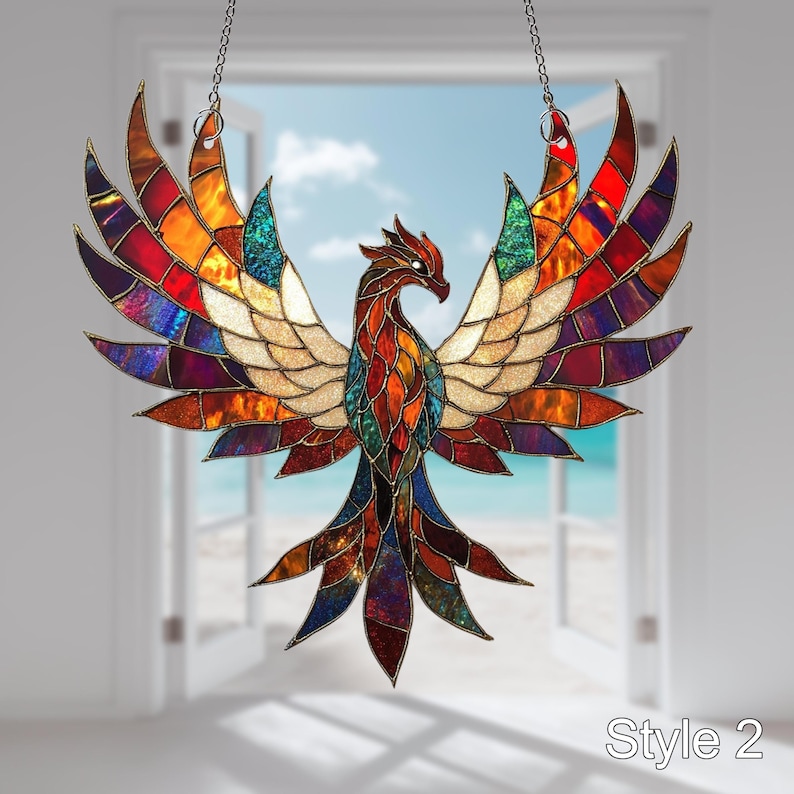 May include: A stained glass window hanging with a colorful phoenix design. The phoenix is made of red, orange, yellow, green, blue, purple, and gold glass. The wings are spread wide and the tail feathers are long and flowing.
