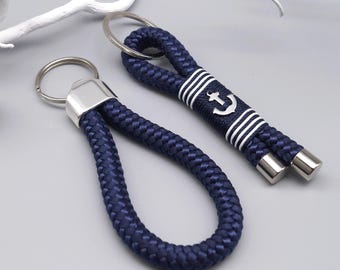 May include: Two navy blue rope keychains with silver key rings. One keychain has a white anchor design with white stripes.