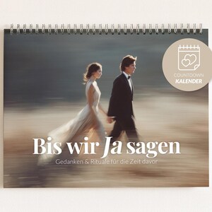 Könnte beinhalten: Ein spiralgebundenes Kalender mit einem verschwommenen Bild eines Paares, das geht. Der Kalender trägt den Text "Bis wir Ja sagen" und "Countdown Kalender". Das Bild zeigt ein Brautpaar.