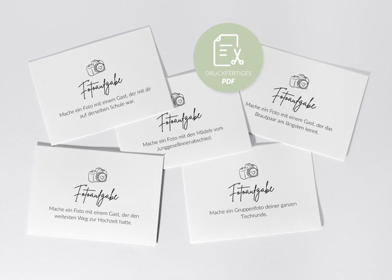 May include: White cards with black text and a camera icon. The cards have different prompts for wedding guests, such as taking a photo with someone from the same school or the longest distance traveled.
