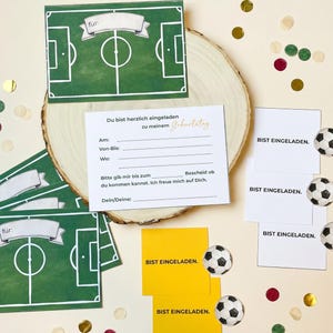 May include: A collection of soccer-themed party invitations and decorations. The invitations feature a green soccer field design with the word "f&uuml;r" on top. Additional cards say "BIST EINGELADEN." and include soccer ball illustrations.