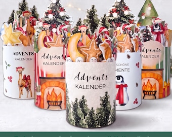 Può includere: Cinque calendari dell'Avvento cilindrici con illustrazioni festive di cervi, pinguini, alberi di Natale e caminetti. Ogni calendario riporta la scritta Advents Kalender e presenta grafiche natalizie come stelle, lune e bastoncini di zucchero.