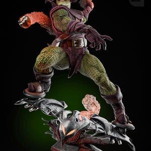 May include: Green Goblin action figure with a green and purple costume, holding a pumpkin bomb. The figure is standing on a black and gray glider with a red and orange glow effect.