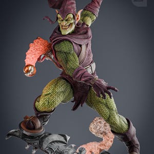 May include: A green and purple action figure of the Green Goblin from the Spider-Man comics. The figure is posed in a dynamic action pose, with one leg raised and the other foot on a glider. The figure has a green, scaly skin, a purple and green costume, and a pointed green hat. The figure is holding a pumpkin bomb in one hand.