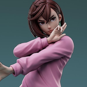 May include: A detailed figurine of a character with short brown hair and red eyes, wearing a pink long-sleeved top. The figure is posed with one hand up near the face and the other extended, with green earrings. The background is a solid teal color.