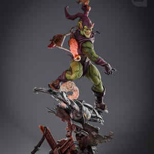 May include: Green Goblin action figure with a purple and green costume, holding a glider and standing on a destroyed building base. The figure has a menacing expression and is ready for battle.