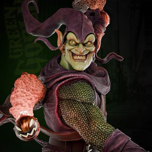 May include: Green Goblin action figure with a purple and green costume, holding a pumpkin bomb. The figure has a green face with a wide grin and pointy ears.