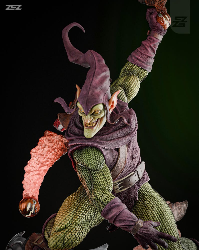 May include: Green Goblin action figure with a purple and green costume, a green face, and a menacing grin. He is holding a pumpkin bomb in his right hand and a glider in his left hand.