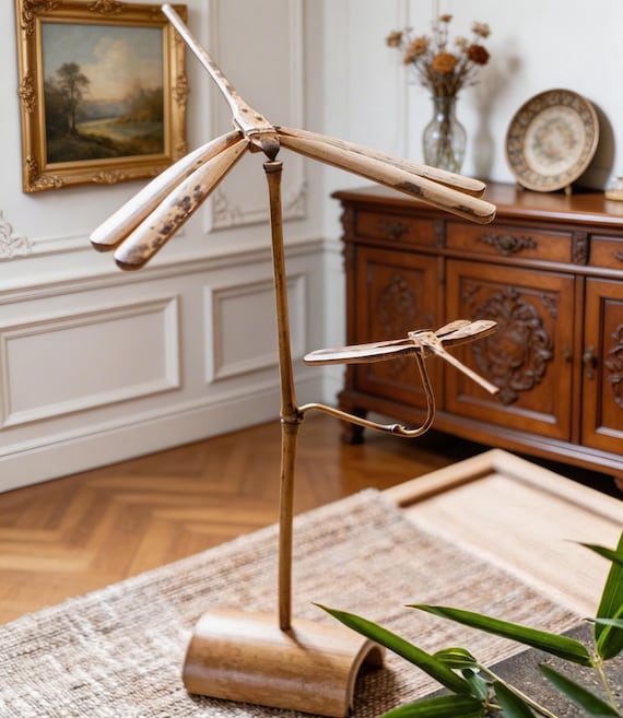 A handmade bamboo dragonfly kinetic balance sculpture with 47 favorites — tactile, zen, and genuinely satisfying to watch drift and sway.