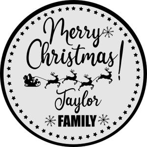 May include: A round, white and black Christmas ornament with the text "Merry Christmas! Taylor FAMILY" and a silhouette of Santa Claus in a sleigh pulled by reindeer.
