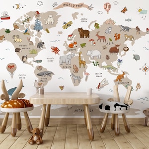 May include: A children's playroom scene featuring a world map wall decal with illustrated animals and landmarks. A small wooden table and two whimsical chairs with animal-themed seats are in front of the map. A teddy bear sits on the floor.