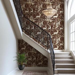 May include: A staircase with a brown and gold deer-patterned wallpaper. A black wrought iron railing runs along the stairs. A crystal chandelier hangs from the ceiling. A potted plant and a patterned rug are at the base of the stairs.