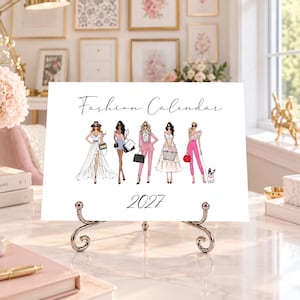 Pode incluir: Um calendário retangular branco intitulado Fashion Calendar 2027, apresentando cinco figuras ilustradas com vários trajes, incluindo vestidos e fatos, com malas e um cão pequeno, exibido num suporte decorativo de metal prateado.