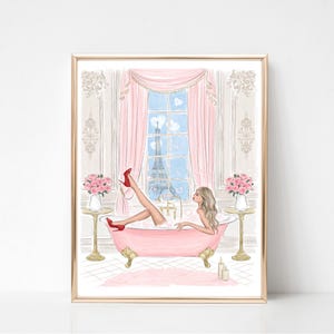May include: A framed art print depicts a woman in a pink bathtub with red heels, bubbles, and a view of the Eiffel Tower. The illustration features pink curtains, flowers, and a gold frame, creating a romantic and elegant aesthetic.