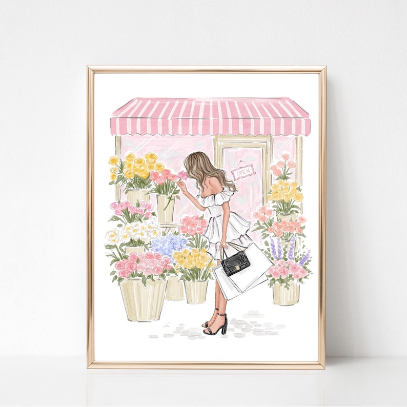 May include: A framed illustration of a flower shop with a pink and white striped awning. A person in a white dress and black heels is smelling a flower. The shop displays various colorful flowers in beige pots. A sign on the door reads "OPEN".