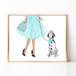 Op de afbeelding: Een vrouw in een lichtblauwe tulejurk en hoge hakken loopt met een dalmati&euml;r die een kroon en een lichtblauwe strik draagt. De hond is aan de lijn.