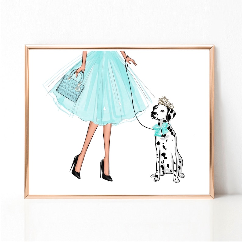 Op de afbeelding: Een vrouw in een lichtblauwe tulejurk en hoge hakken loopt met een dalmati&euml;r die een kroon en een lichtblauwe strik draagt. De hond is aan de lijn.