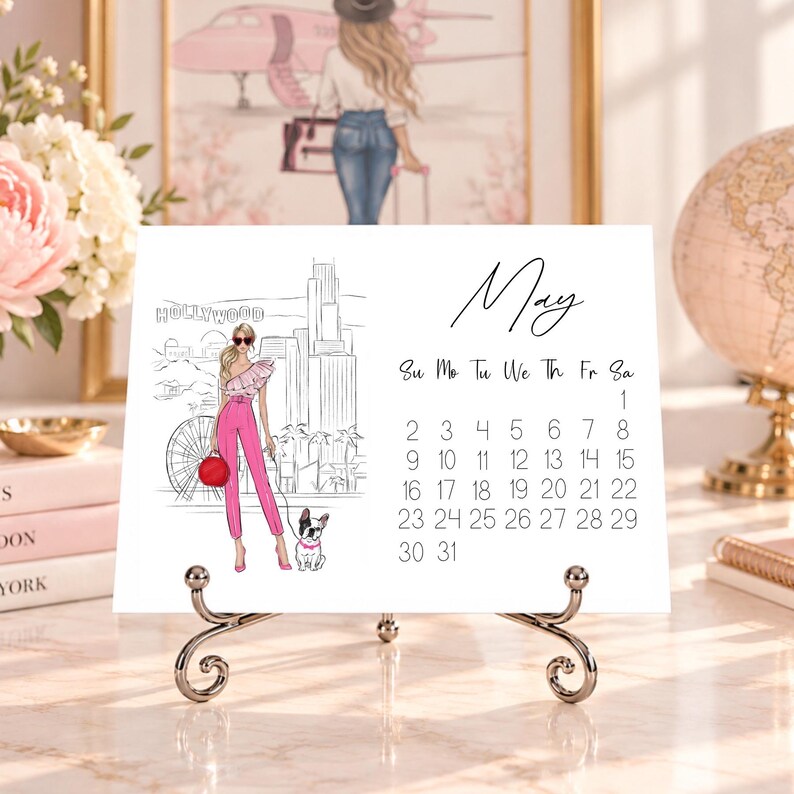 Pode incluir: Uma p&aacute;gina de calend&aacute;rio de mesa branca para o m&ecirc;s de maio, com um desenho de linha em preto e branco de uma pessoa com um conjunto rosa, uma bolsa vermelha e um c&atilde;o num cen&aacute;rio urbano com a palavra Hollywood, num suporte de metal prateado.