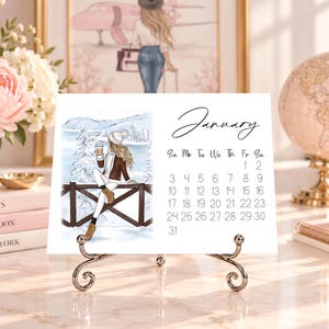 Pode incluir: Uma p&aacute;gina de calend&aacute;rio de mesa branca para janeiro com um cabe&ccedil;alho em letra cursiva preta e uma grade de datas. O lado esquerdo exibe uma ilustra&ccedil;&atilde;o de uma pessoa com longos cabelos loiros, gorro branco, jaqueta e botas marrons.