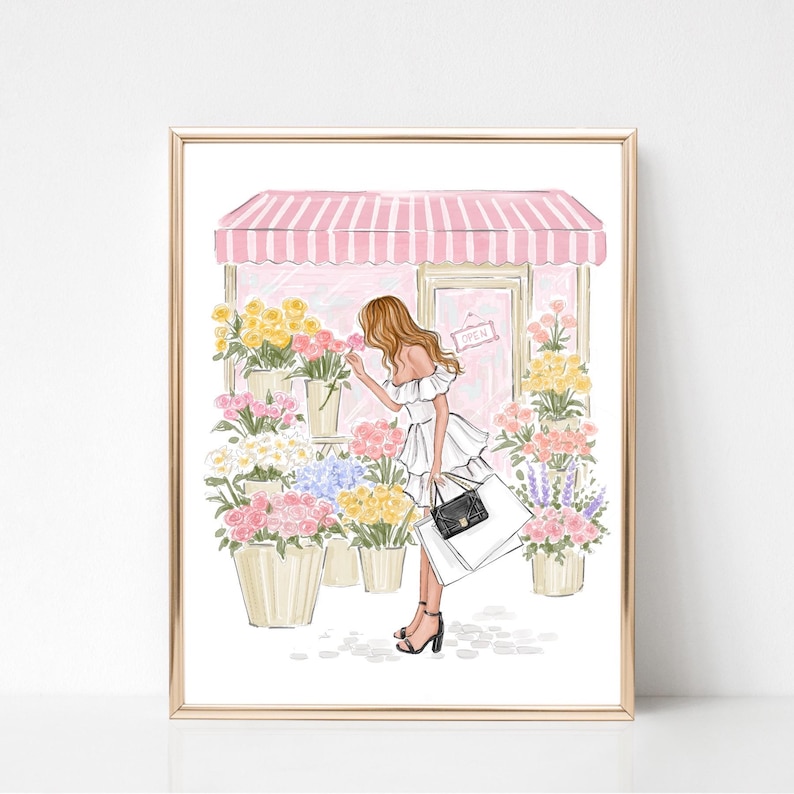 May include: A framed illustration of a woman smelling flowers outside a flower shop. The shop has a pink and white striped awning and the door has an "OPEN" sign. The woman is wearing a white dress and carrying shopping bags. Various colorful flowers are displayed in pots.