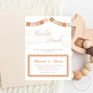 Op de afbeelding: Een babyborrel uitnodiging in perzik en bruine tinten. De uitnodiging heeft een banner met traditionele Mexicaanse papieren decoraties, wolken en de tekst "Cielito Lindo". De uitnodiging bevat ook de namen "Bianca & Dario", de datum en tijd van de borrel, het adres, RSVP-informatie en de registratie locatie.