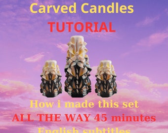 May include: Three carved candles with intricate designs in shades of white, yellow, and black. The candles are arranged in a row against a pink and purple cloudy sky. The text "Carved Candles TUTORIAL How i made this set ALL THE WAY 45 minutes English subtitles" is displayed below the candles.