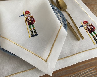 Elegant White Linen Embroidered Tableware Set with Flag Holding Nutcracker Design; Nutcraker Embroidered Napkins, Placemats, Table Runner