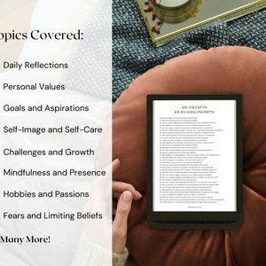May include: An e-reader displaying "100 Self-Reflection Journaling Prompts" rests on a brown cushion. The topics covered include daily reflections, personal values, goals, self-image, challenges, mindfulness, hobbies, and fears. A gold-rimmed magnifying glass is nearby.