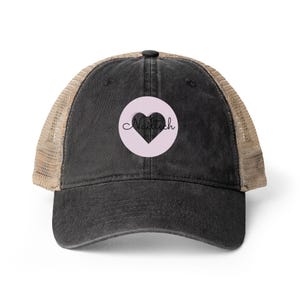 May include: A black trucker hat with a tan mesh back. The front features a light pink circle with a black heart and the word "Nailtech" in cursive.