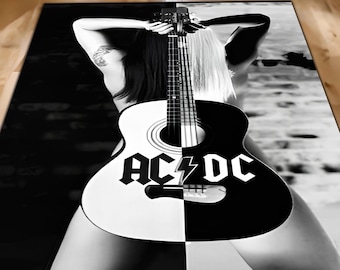 May include: Black and white rug featuring a woman holding an acoustic guitar with the word "AC/DC" on the front. The guitar is split down the middle, with one half black and the other half white.