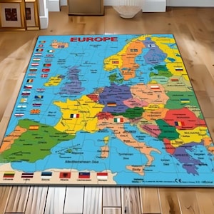 Puede incluir: Una alfombra rectangular con un mapa colorido de Europa, con cada país delineado y etiquetado. Las banderas de cada nación se muestran a los lados. La palabra "EUROPE" está impresa en rojo en la parte superior.