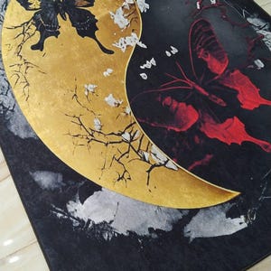 May include: Black and gold rug with a yin yang design featuring butterflies. The yin side is gold with a black butterfly and the yang side is black with a red butterfly.