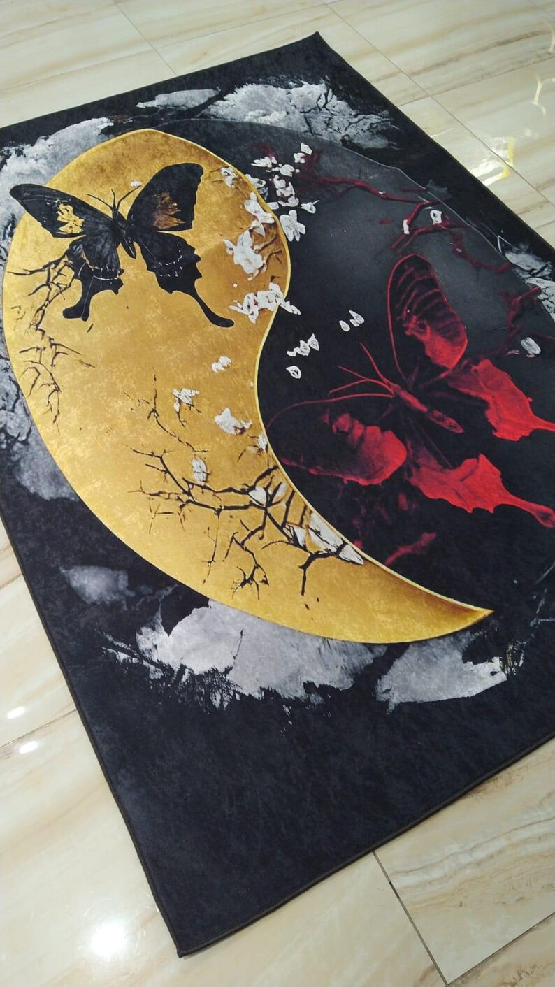 May include: Black and gold rug with a yin yang design featuring butterflies. The yin side is gold with a black butterfly and the yang side is black with a red butterfly.