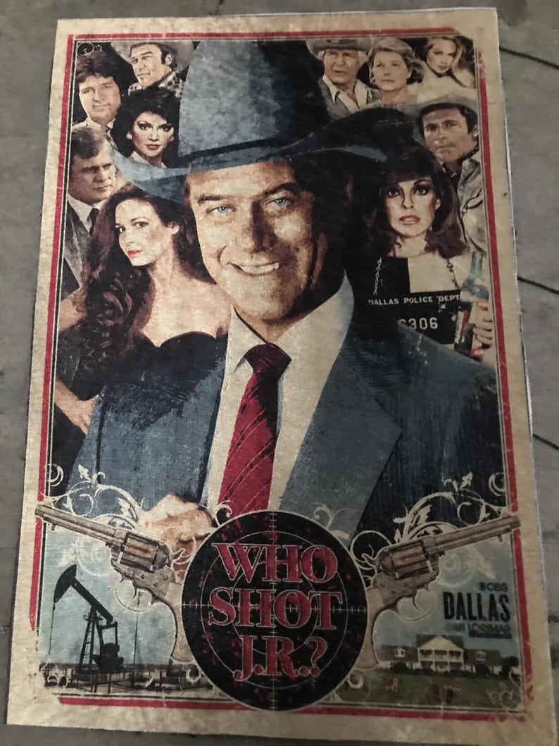 May include: A vintage poster with the text "WHO SHOT J.R.?" and images of people, guns, an oil rig, and a house. The central figure is a smiling man in a hat. The poster has a red border and a distressed look.
