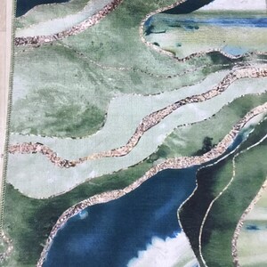 May include: Abstract rug with a green, blue, and white color scheme. The rug features a swirling, organic pattern with gold accents.