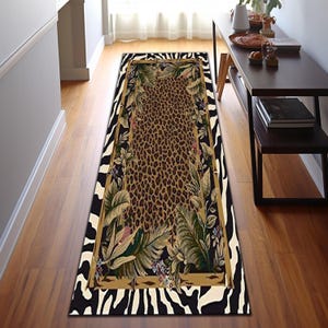 May include: A rectangular runner rug with a bold design. The center features a leopard print, framed by a gold border and tropical foliage. The outer border has a black and white zebra stripe pattern.