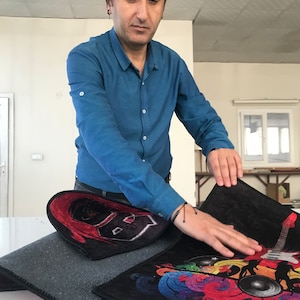May include: Three different rugs with colorful designs. One rug features a black and red guitar with a white letter B. Another rug has a colorful design with a guitar, musical notes, and speakers. The third rug is a solid dark gray color.