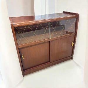 1950 年代にドイツで製造された、非常に良好なヴィンテージ状態のクルミ材を使用したミッドセンチュリーのバー / メディア キャビネット / サイドボードです。