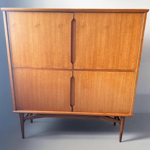 Puede incluir: Un aparador de madera de estilo moderno de mediados de siglo con cuatro puertas y un dise&ntilde;o sencillo. El aparador tiene un acabado de madera clara y se apoya en cuatro patas delgadas.
