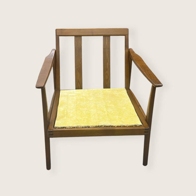 May include: A wooden armchair with a yellow cushion. The chair has a rectangular seat and a back with three vertical slats. The arms are curved and the legs are straight. The wood has a warm, brown tone.