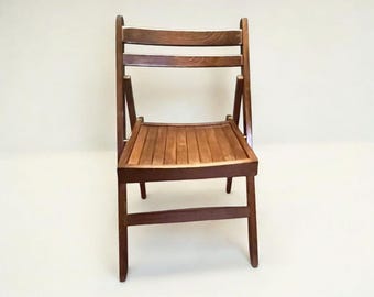 This original Italian vintage folding chair is a solid mid-century classic made of solid wood with a timeless design.
