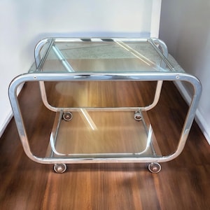 Space Age serving cart/trolley or side table made of chrome and glass. 1970s bar cart with a beautifully curved chrome frame.