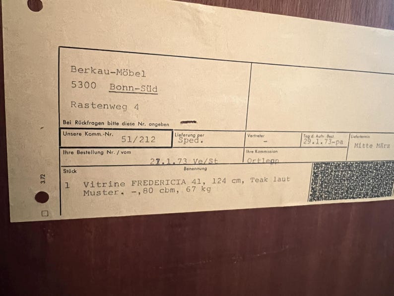 Puede incluir: Un primer plano de una factura de papel para una vitrina Fredericia 41 de 124 cm de teca. La factura indica que el art&iacute;culo mide 0,8 metros c&uacute;bicos y pesa 67 kg.