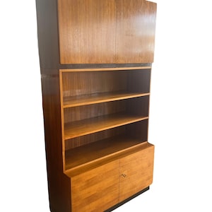 Puede incluir: Un mueble de madera de estilo moderno de mediados de siglo con un acabado marr&oacute;n claro. El mueble cuenta con almacenamiento superior con dos puertas, estanter&iacute;as abiertas y almacenamiento inferior con dos puertas. Dise&ntilde;o vertical.