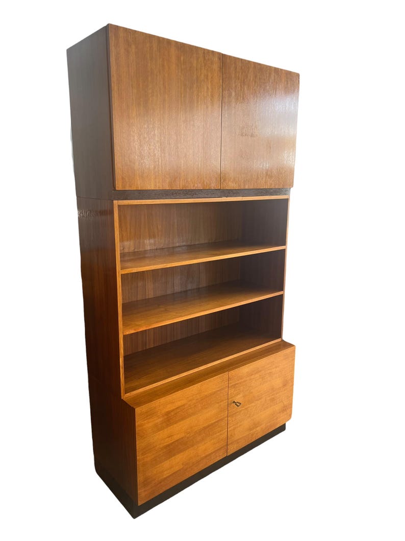 Puede incluir: Un mueble de madera de estilo moderno de mediados de siglo con un acabado marr&oacute;n claro. El mueble cuenta con almacenamiento superior con dos puertas, estanter&iacute;as abiertas y almacenamiento inferior con dos puertas. Dise&ntilde;o vertical.